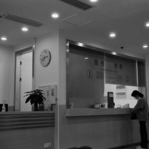 a black and white photo of a woman standing in front of a counter
